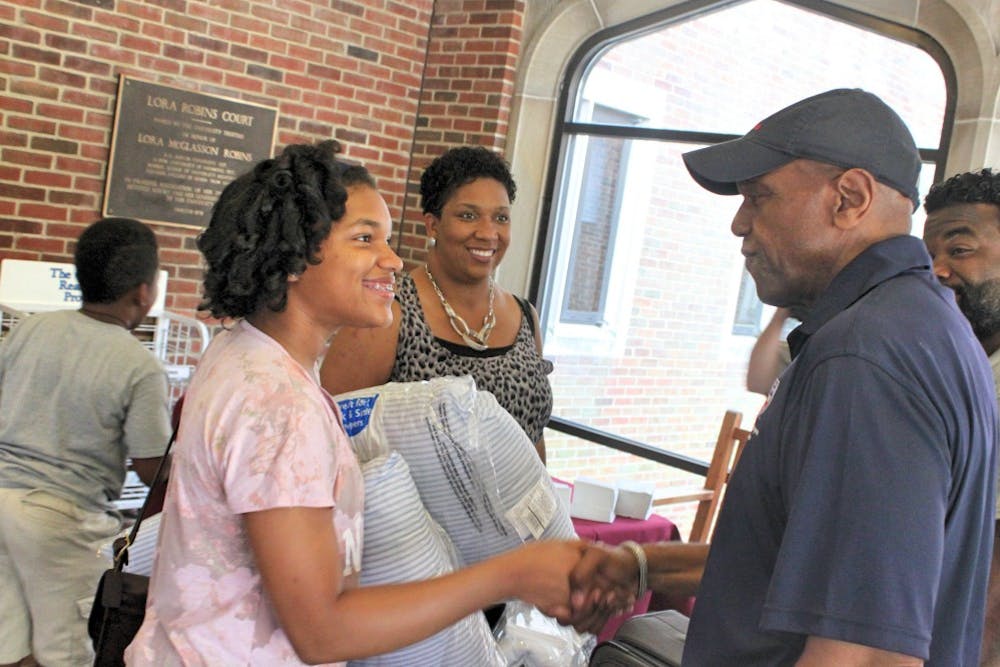 <p>Ronald Crutcher (right) greeted new students and assisted new student move-in day around campus before welcoming new students in the Robins Center Wednesday night.</p>
