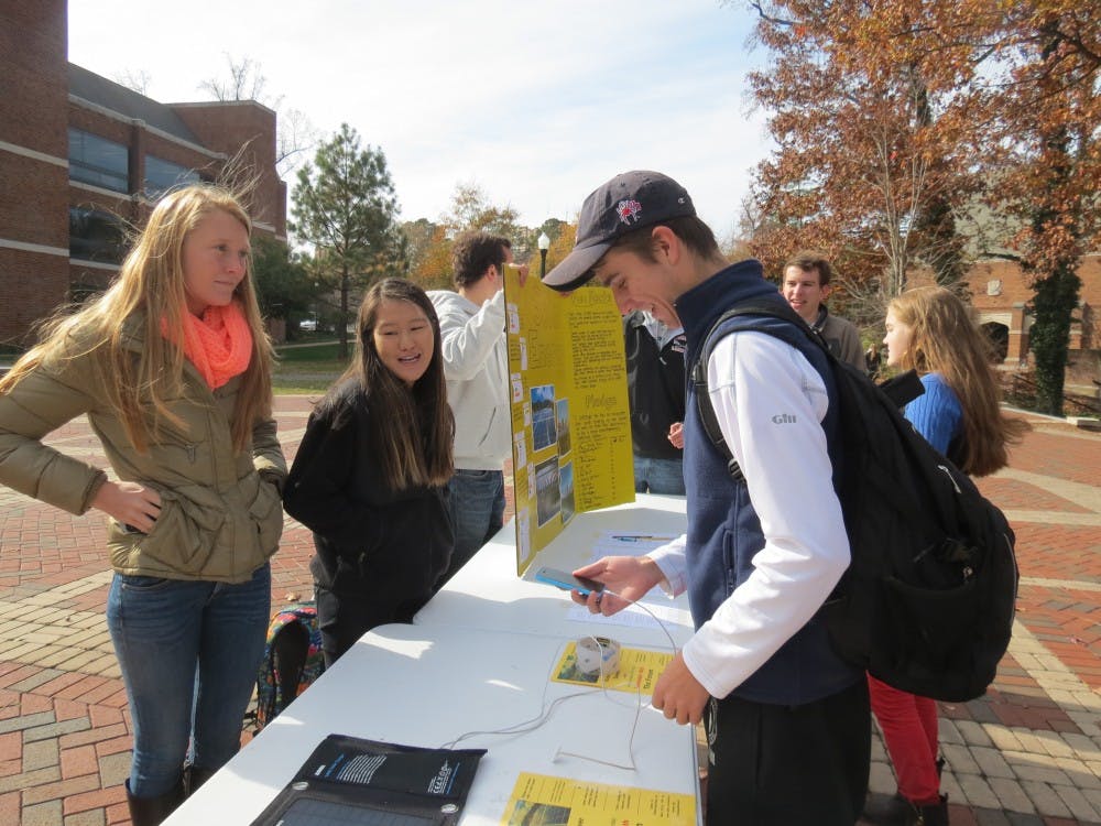 Haley Close, left, and Jacqueline Sinnott, center, discuss how solar power can be implemented on the university campus to students in the forum. Photo by Chase Brightwell.