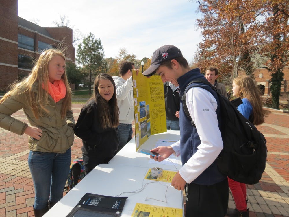 <p>Haley Close, left, and Jacqueline Sinnott, center, discuss how solar power can be implemented on the university campus to students in the forum. Photo by Chase Brightwell.</p>