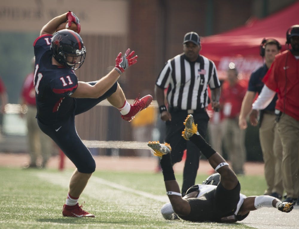 <p>Tight end Garrett Hudson tries to avoid a tackle from a Towson defender during Saturday's game.&nbsp;</p>