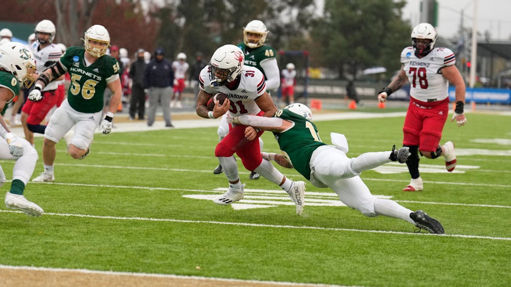Redshirt senior running back Milan Howard runs while being tackled by a California State University, Sacramento player at the Football Championship Subdivision playoffs on Dec. 3. Photo courtesy of Richmond Athletics.