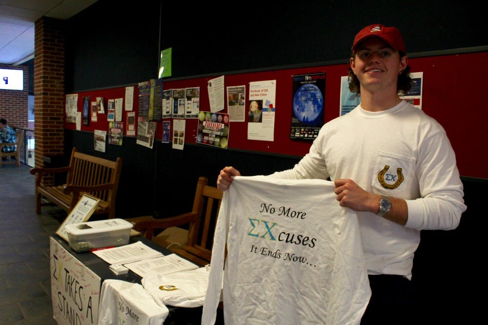 <p>Sigma Chi fraternity member Miller Joyce holds up one of the shirts being sold&nbsp;in the Commons this week.</p>