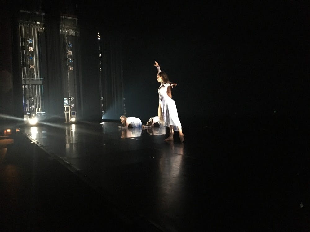 Karen Fleming (standing), Gianna Dowd and Edie Sanders rehearse senior Cristina Peters's dance, "Sonámbula," as Peters takes notes from the audience. 
