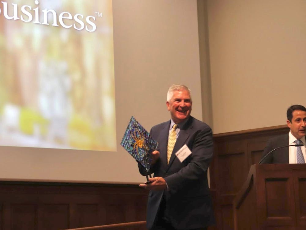 Stephen J. Kneeley accepts a memento as they induct him into the E. Claiborne Robins School of Business Hall of Fame on Nov. 3, 2022.