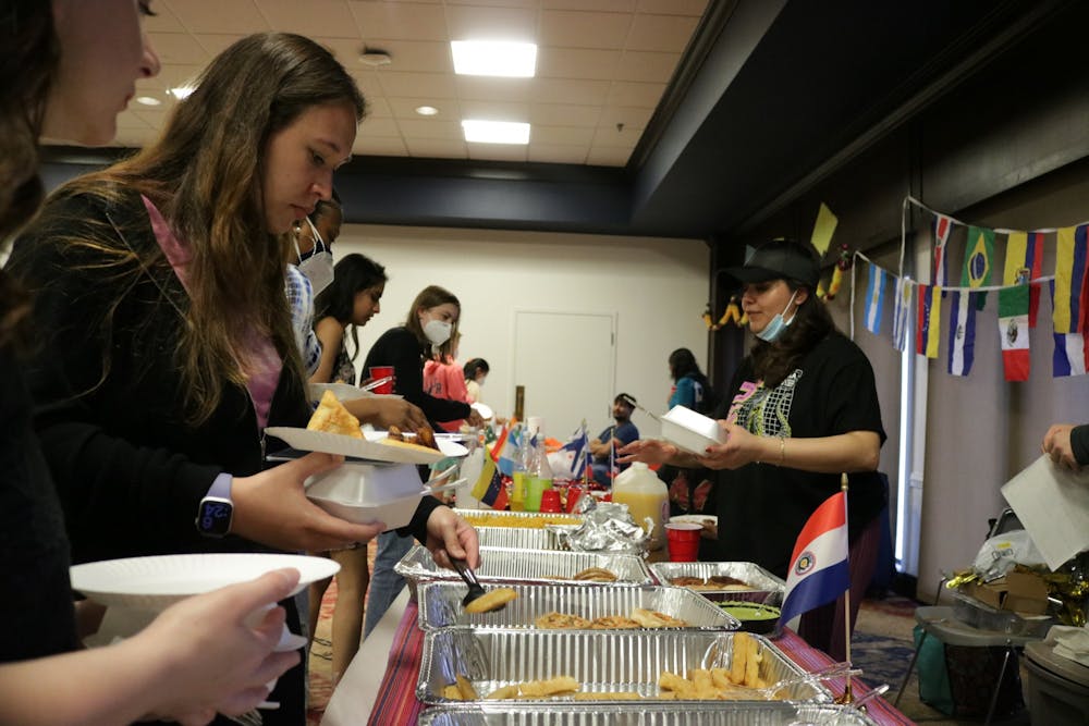 <p>Students get food from the Solidarity Organization for Latinx Students table at "A Taste of the World" on April 16.</p>