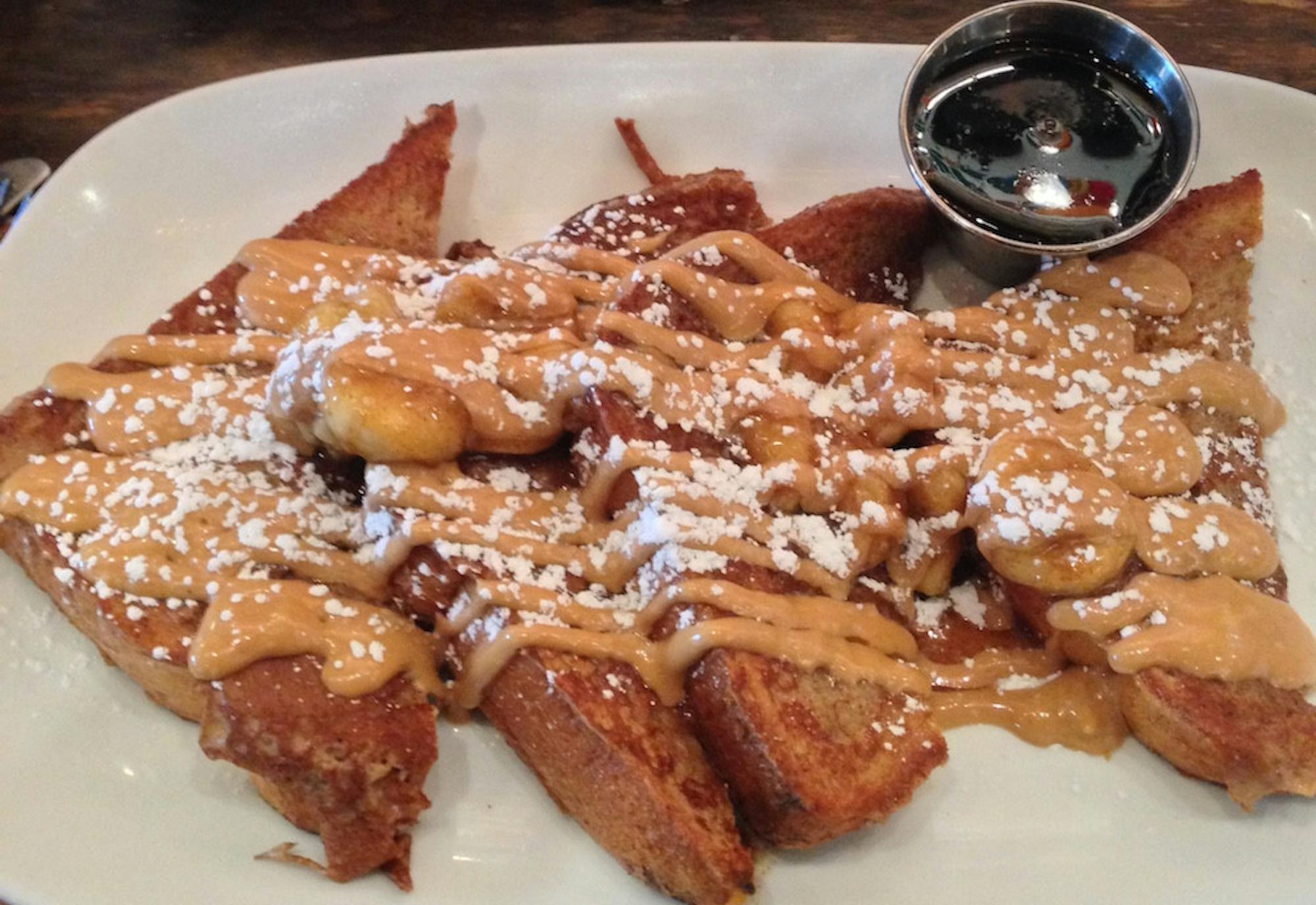 Peanut butter and bananas lie gratuitously on top of fresh homemade challah French Toast at Folk Art, a southern-inspired brunch spot in Inman Park, nestled between Little Five Points and The Carter Center.