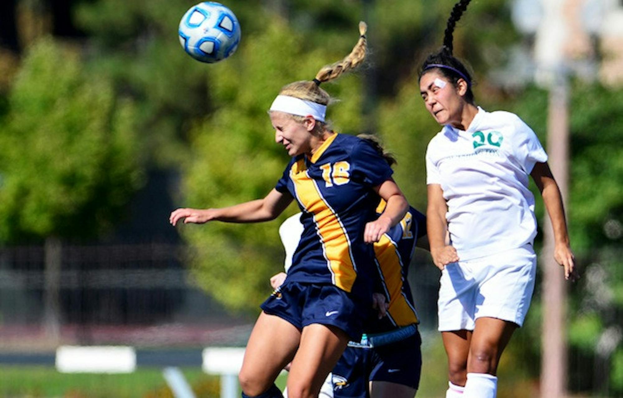 Junior midfielder Ally Peterson leaps in front of a Washington University (Mo.) player to head the ball. The No. 5-ranked Eagles tied the No. 1-ranked Bears 1-1 through double-overtime last Sunday. / Courtesy of Emory Athletics