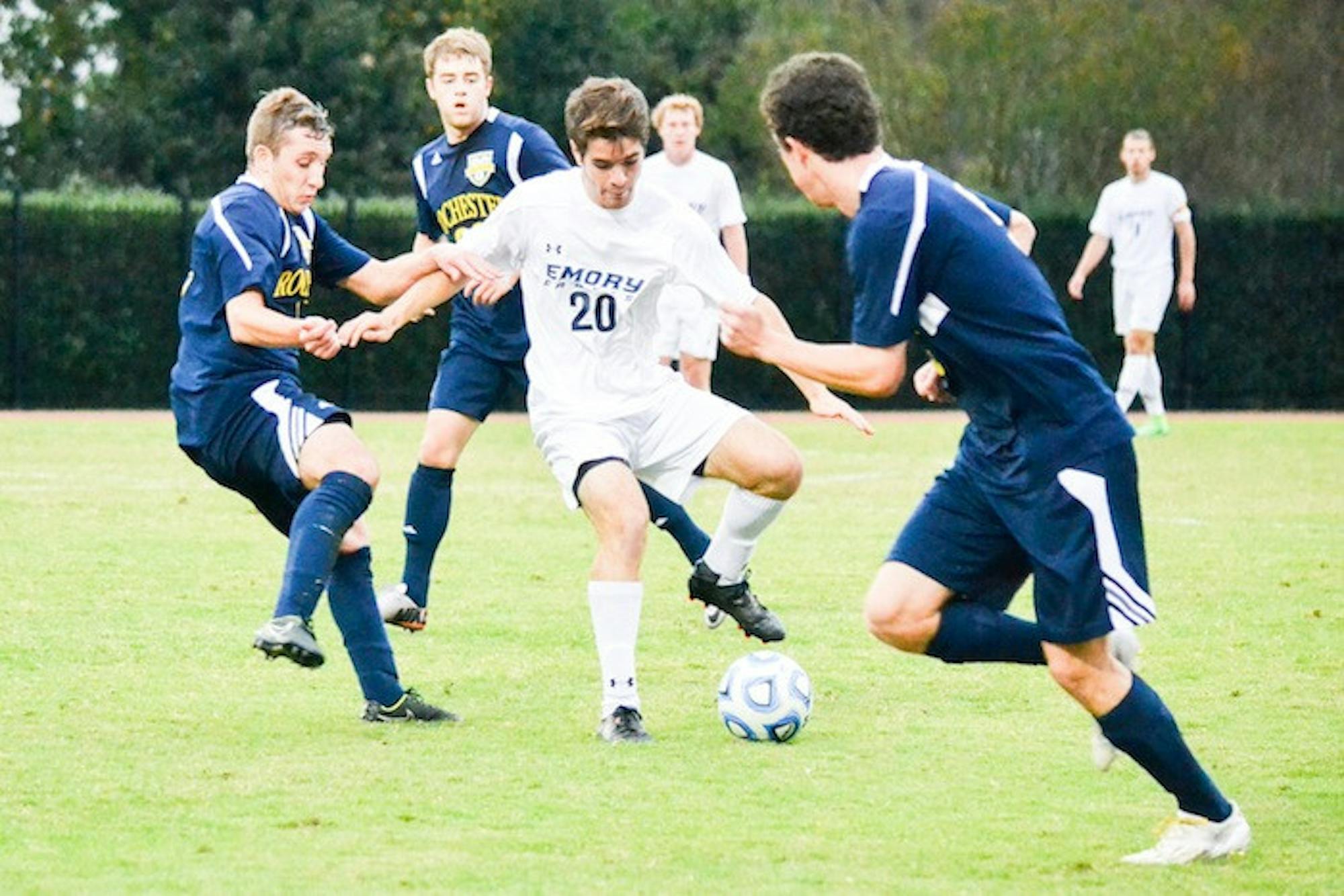 Sophomore midfielder Eli Curtin dribbles around University of Rochester (N.Y.) defenders. Curtin and the Eagles shut out the Yellowjackets 1-0 last Friday for the team's Senior Day. The Eagles are now 3-3 in University Athletic Association (UAA) play on the season. | Photo by Erin Baker, Staff Photographer