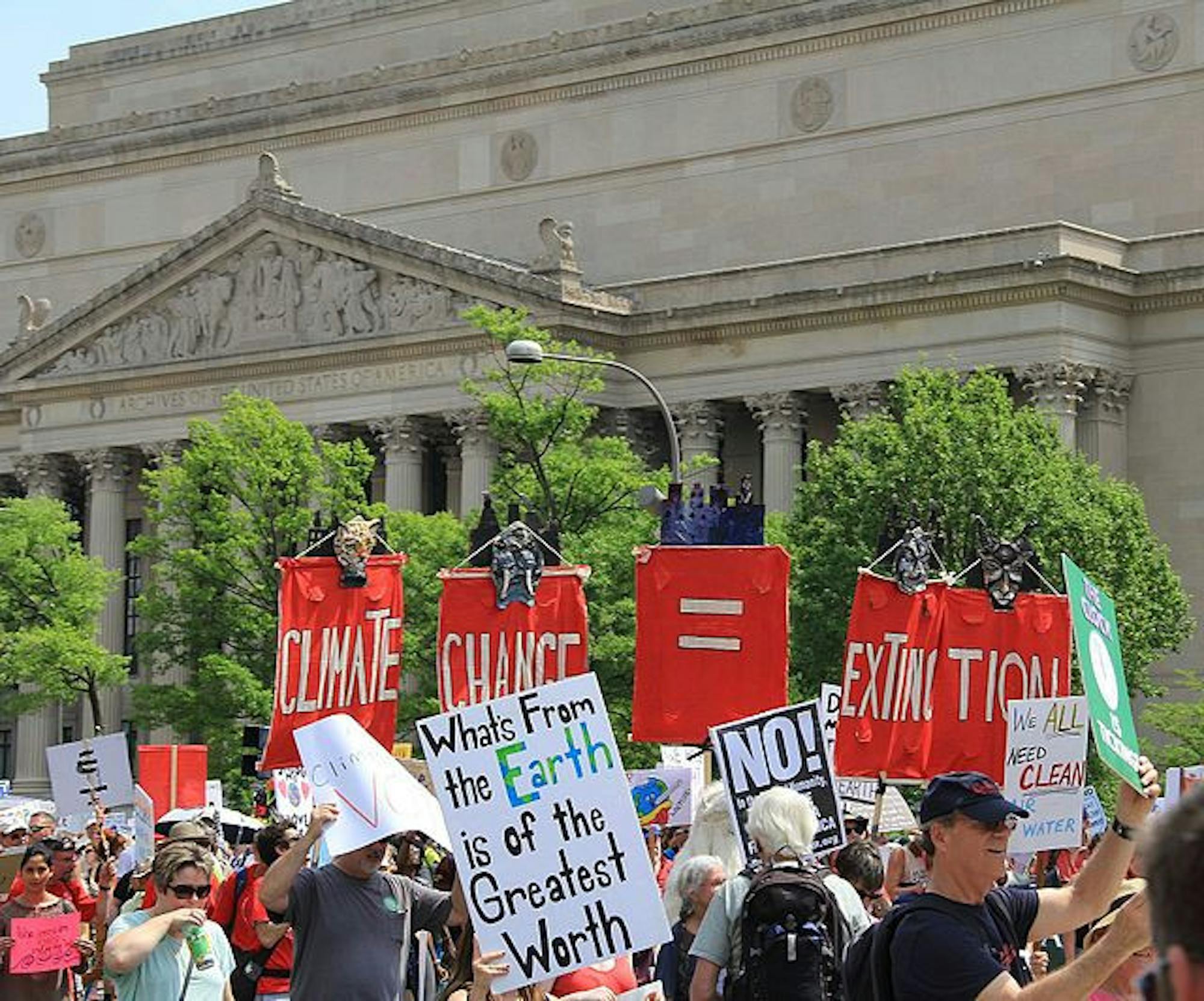 Peoples_Climate_March_2017_in_Washington_DC_25_-_Marchers_pass_the_US_National_Archives_with_signs__What_comes_from_Earth_is_of_the_Greatest_Worth___Climate_Change_Equals_Extinction_